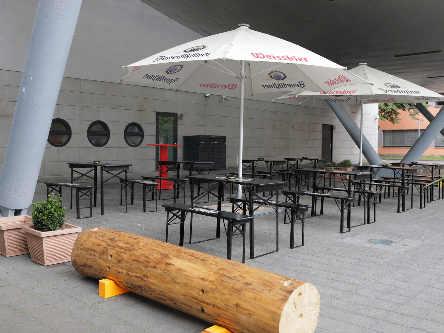 Außenbereich mit Biergarnituren und Sonnenschirmen am Filmpalast